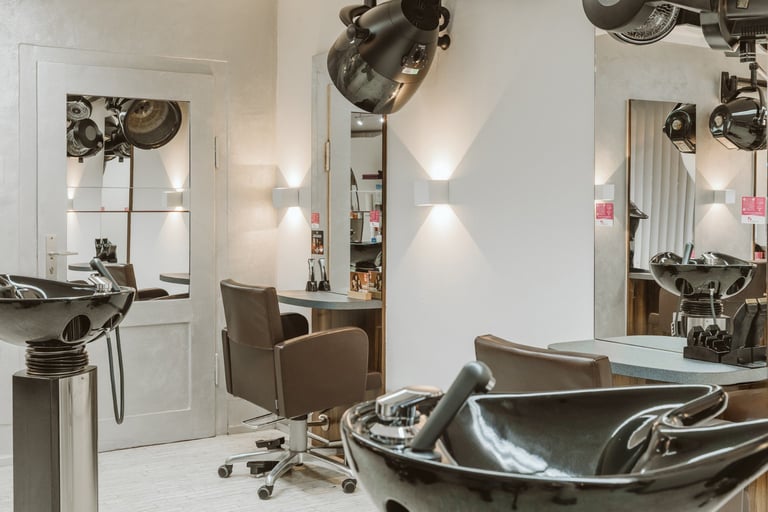 Modern hair salon interior with styling chairs, wash stations, mirrors, and professional lighting fixtures